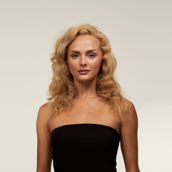 Młoda kobieta z lśniącymi, rozjaśnionymi blond włosami, efekt szamponu z cytrusami i rumiankiem.