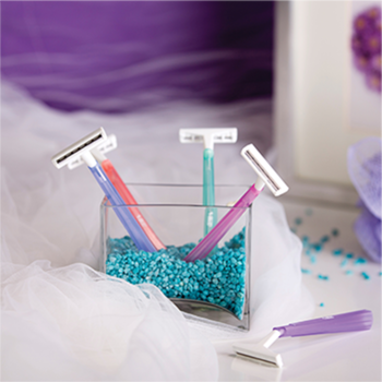 Jednorazowe maszynki BIC Twin Lady, trzy w szklanym pojemniku z koralikami, jedna obok, pastelowe kolory.