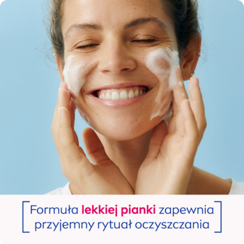 Zbliżenie na kobietę z uśmiechem, nakładającą puszystą piankę NIVEA do oczyszczania twarzy na policzki.