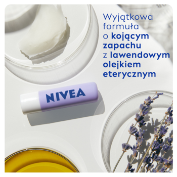 Fioletowa pomadka Nivea Overnight w laboratoryjnym ujęciu, otoczona lawendą i naczyniami ze składnikami.