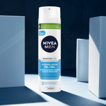 Pionowa biała puszka NIVEA MEN Sensitive Cool Żel do golenia, z granatową etykietą, na tle jasnoniebieskich bloków.
