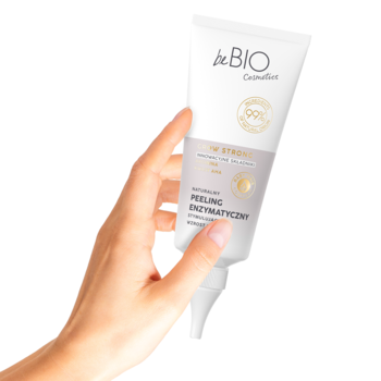 Biała tuba beBIO Enzymatyczny Peeling do skóry głowy z aplikatorem, trzymana w dłoni.