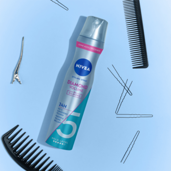 NIVEA Diamond Volume lakier do włosów, poziom 5, srebrna butelka na niebieskim tle, z grzebieniami i spinkami.