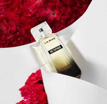 La Rive Metaphor damska woda perfumowana. Elegancki flakon z jasnym gradientem, otoczony czerwonymi goździkami.