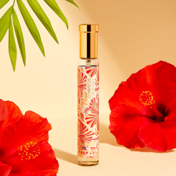 Adopt' Fleur d’hibiscus perfumy damskie, smukła butelka z barwnym wzorem, otoczona czerwonymi hibiskusami.