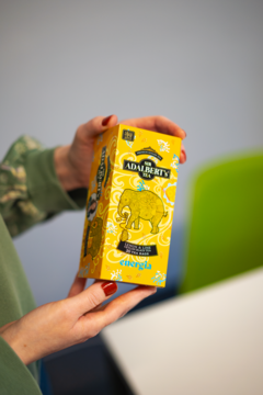 Żółte pudełko herbaty Adalbert’s Tea Lemon & Lime ENERGIA, z wizerunkiem słonia, trzymane w dłoniach.