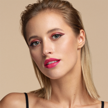 Blondynka z różowym makijażem oczu i ust, podkreślone rzęsy Catrice Insane Length Lashes, neutralne tło.