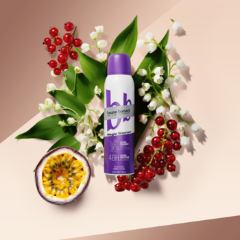 Bruno Banani Magic Woman antyperspirant w fioletowej puszce, otoczony konwaliami, czerwonymi jagodami i marakują, widok z góry.