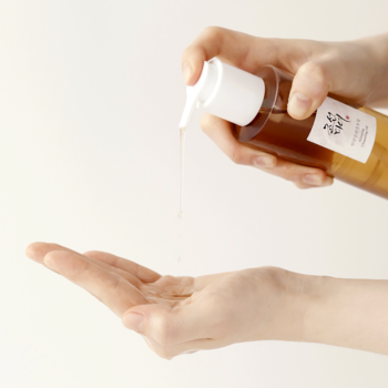 Beauty of Joseon Ginseng Cleansing Oil, olejek do demakijażu, osoba wylewa go z butelki na dłoń.