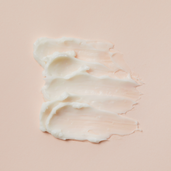 Comfort Ceramide Cream Cosrx: biały, kojący krem z ceramidami w trzech smugach na różowym tle, matowe wykończenie.