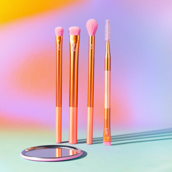 Zestaw Real Techniques Hyperbrights Bold Type Eye: 4 różowo-złote pędzle do oczu i różowe lusterko na barwnym tle.