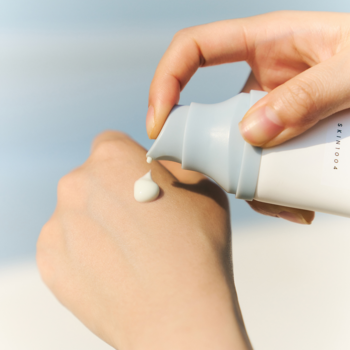 Osoba aplikuje Skin1004 Hyalu-Cica Water-Fit Sun Serum SPF50+ z pompki na skórę dłoni.