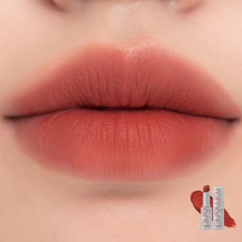 Usta z matową szminką Rom&nd Zero, ciepły ceglasty odcień. Widoczne opakowania i swatch produktu.