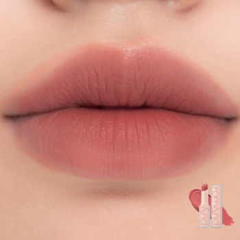 Matowa szminka Rom&nd Zero Lipstick nr 07 na ustach, widok z bliska, naturalny odcień beżowo-różowy.