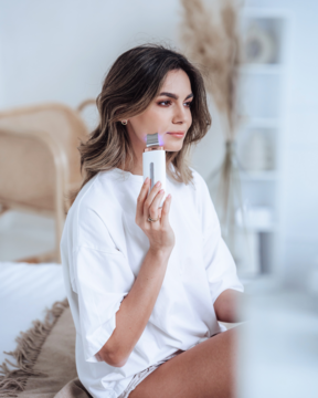 Kobieta używa białego peelingu kawitacyjnego Beautifly B-Scrub PRO do twarzy w domowym zaciszu.