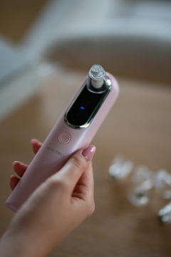 Różowe urządzenie Beautifly B-Derma Blush do mikrodermabrazji diamentowej, trzymane w dłoni, z ekranem.