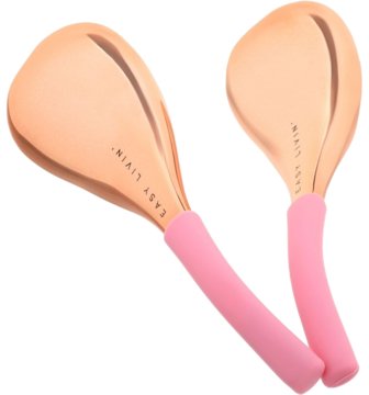 Dwie lśniące łyżki Easy Freezy Spoons do masażu twarzy, miedziane głowice i różowe uchwyty silikonowe.