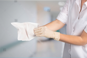 Rękawice myjące Serenity Care: osoba zakłada beżową rękawicę, trzymając chusteczkę, do pielęgnacji bez wody.