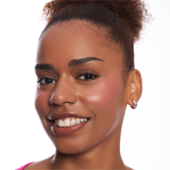 Uśmiechnięta kobieta prezentująca efekt naturalnych rumieńców z różu w sztyfcie Essence Baby Got Blush Rose All Day.