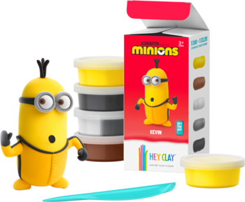 Zestaw Hey Clay Minionki: duża żółta figurka Minionka, 5 kolorowych mas plastycznych i narzędzie, obok czerwone pudełko.