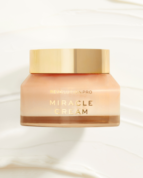 Revolution PRO Miracle Cream, beżowy krem do twarzy w transparentnym słoiku ze złotą zakrętką, widok z przodu.