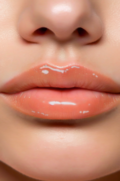 Zbliżenie na usta z transparentnym błyszczykiem Pheym Kiki, dającym efekt „wet look” i optycznie je powiększającym.