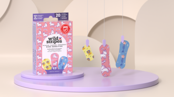 Różowe pudełko Wild Stripes Kids Sensitive, plastry dziecięce z jednorożcami i syrenkami. Trzy kolorowe plastry wiszą.