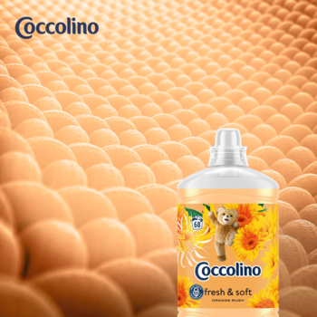 Coccolino Fresh & Soft Orange Rush płyn do płukania z misiem na tle puszystej pomarańczowej tkaniny.