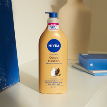NIVEA Body Lotion Cocoa Nourish, karmelowa butelka z niebieską pompką, 48h nawilżenia, widok z przodu.