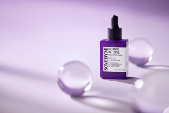 Fioletowe serum Some By Mi Retinol Intense z pipetą, widok z przodu na lawendowym tle z przezroczystymi kulami.