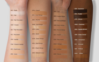 Swatche podkładów TIRTIR na czterech ramionach demonstrujące szeroką gamę odcieni skóry.