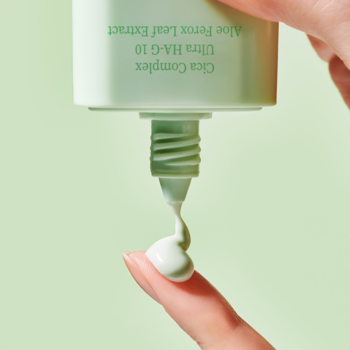 Serum przeciwsłoneczne Tocobo Cica Calming SPF 50+ w zielonej tubce, wyciskane na palec, widok z bliska.