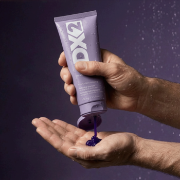 Fioletowy szampon DX2 Men Shampoo do siwych włosów wyciskany z tuby do dłoni, neutralizuje żółte tony.