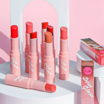 Kolekcja różowych, nawilżających balsamów do ust J.Cat Beauty Dew Glow w sztyfcie, stojących i leżących.