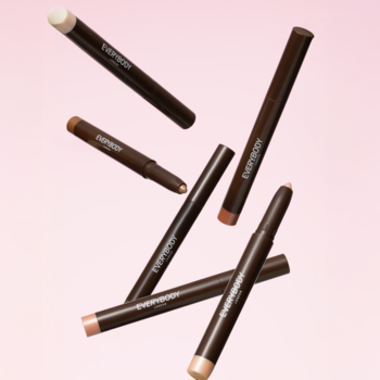 Kilka brokatowych cieni Everybody London Shimmer Pen w kredce, w różnych odcieniach, unosi się na różowym tle.