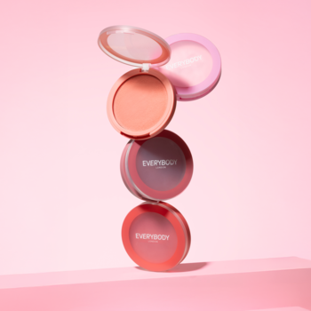 Kremowe róże Everybody London: brzoskwiniowy otwarty, bordowy i koralowy, ułożone jeden na drugim na różowym tle.