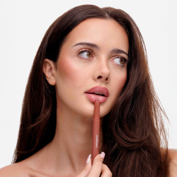 Modelka nakłada na usta Blending Lip Crayon Rosy Sand, satynową konturówkę Everybody London.