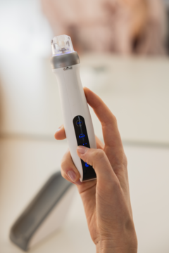 Biały Beautifly Dermapen CollagenBoost PRO, urządzenie do mezoterapii, trzymane w dłoni, z niebieskimi światłami LED.