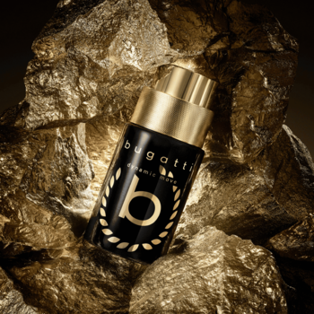 Bugatti Dynamic Move Intense, męska woda perfumowana w czarnej butelce ze złotym korkiem, na tle złotej rudy.