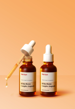Ampułka do twarzy manyo Bifida Biome Complex w dwóch brązowych butelkach z kroplą produktu na zakraplaczu.