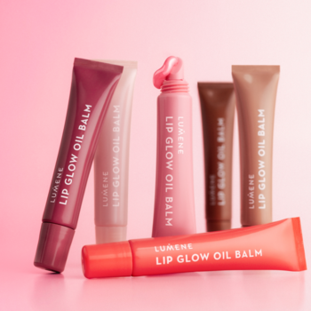 Sześć błyszczących Lumene Lip Glow Oil Balm w różnych odcieniach, z jednym wyciśniętym produktem, na różowym tle.