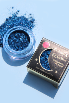 Chromatyczny niebieski pigment Vanity Goddess w słoiczku i pudełku na jasnoniebieskim tle.