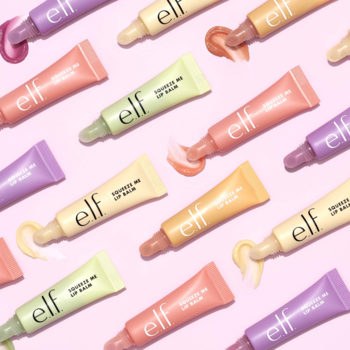 elf Squeeze Me Lip Balm, wiele pastelowych tubek na różowym tle, widok z góry, z wyciśniętym produktem.