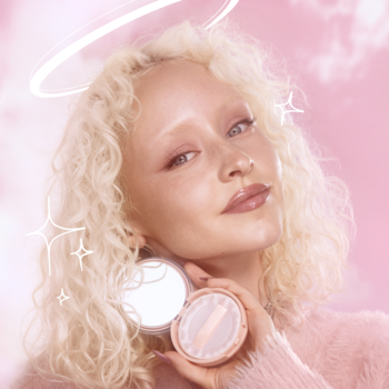 Blondynka z efektem halo trzyma otwarty puder e.l.f. Halo Glow Fair Warm z lusterkiem i welurową pufką.