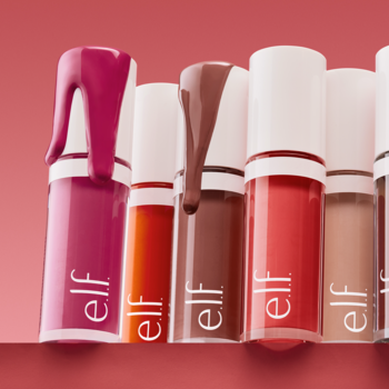 Zbliżenie na kolekcję błyszczyków e.l.f. Cosmetics w wielu odcieniach, z kapiącym żelem, na czerwonym tle.