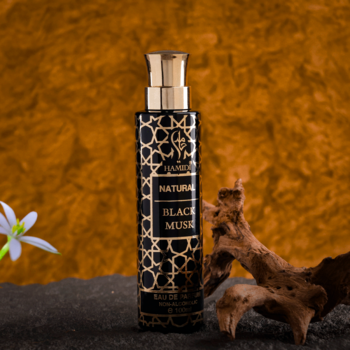 Natural Black Musk HAMIDI Oud w czarnej butelce ze złotym geometrycznym wzorem, złotą zakrętką, na ciemnym tle, z drewnem.