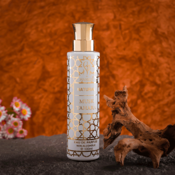 Perfumy Datura Musk Tahara w białej butelce ze złotymi orientalnymi wzorami, na tle pomarańczowym z drewnem.