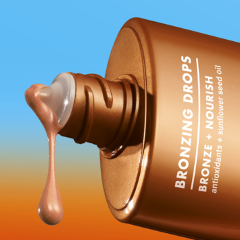 e.l.f. Skin Kropelki brązujące Rose Gold. Zbliżenie na brązową butelkę z kroplą płynu spływającą z aplikatora.