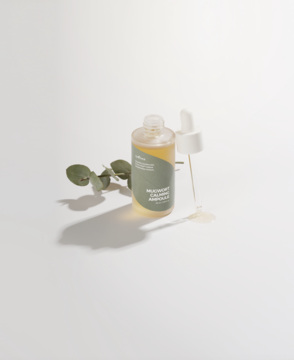 Kojąca ampułka Isntree Mugwort Calming Ampoule, butelka z pipetą, krople serum i gałązka piołunu na białym tle.