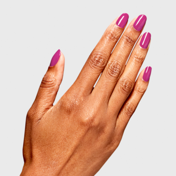Lakier OPI RapiDry Asapink. Zbliżenie na dłoń z lśniącym, intensywnym fuksjowym manicure, szare tło.